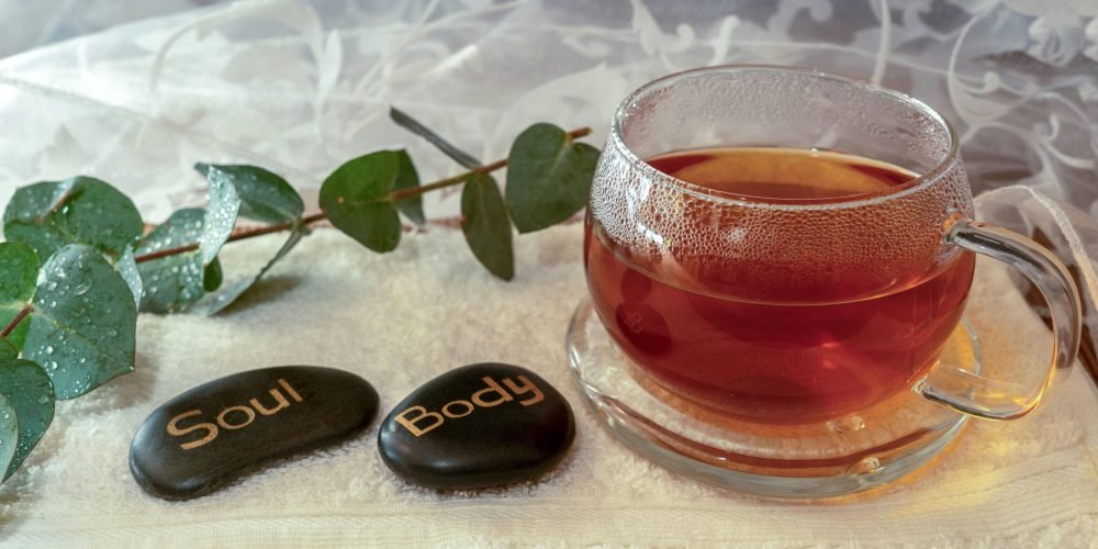 Relaxing scene with herbal tea and stones symbolizing soul and body harmony.